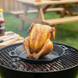 Chicken sitter op de BBQ met een gebraden kip erop